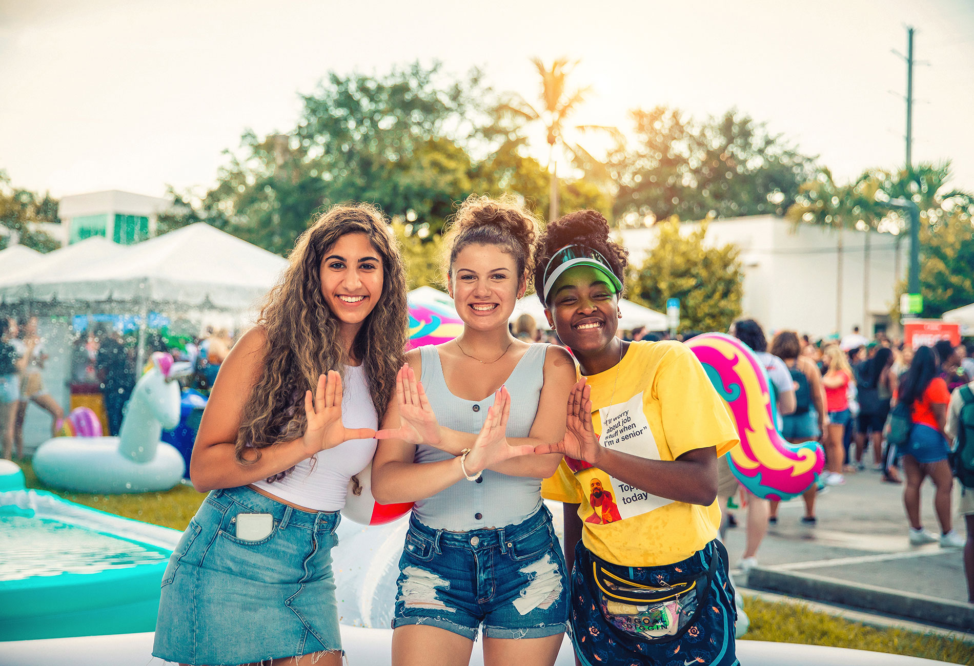 Spirited students on campus holding up the U sign with their hands.