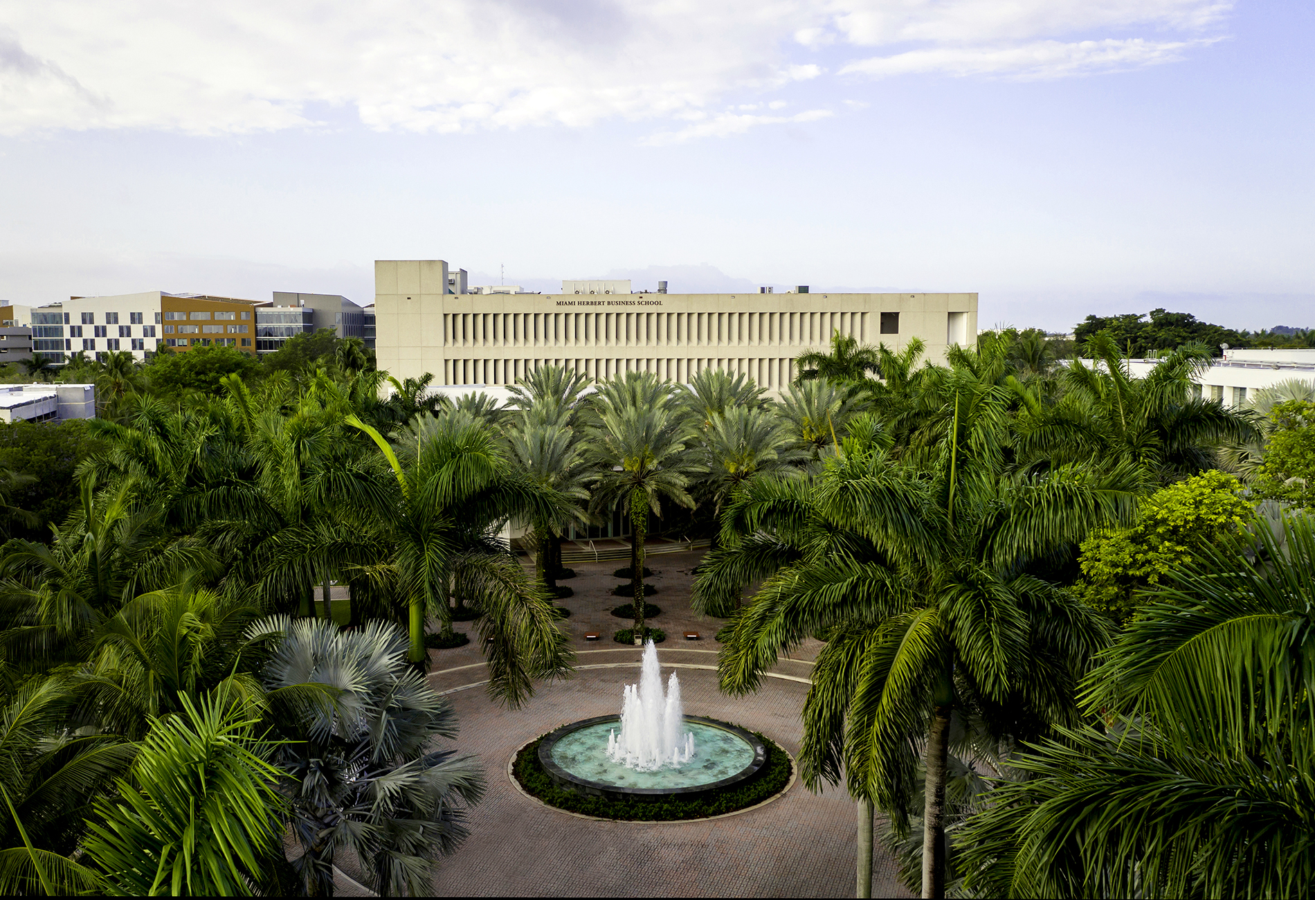 Aerial view of Miami Herbert Business school building, fountain and palm trees in the foreground. 