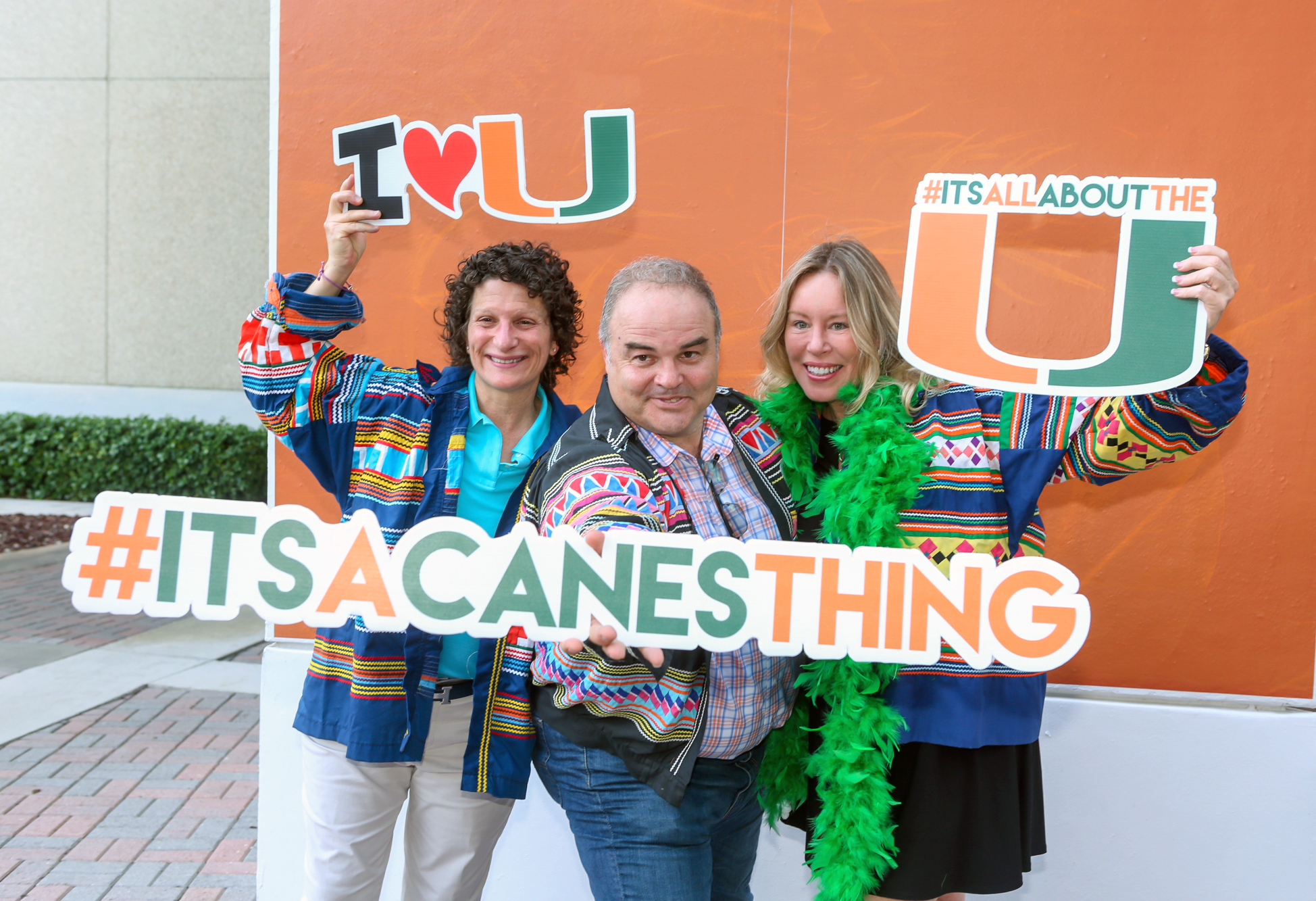 Miami Herbert alumni dressed in orange and green celebrating homecoming.