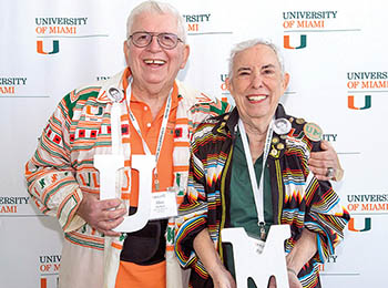 Patti and Allan Herbert pose together wearing Miami-Herbert colors 