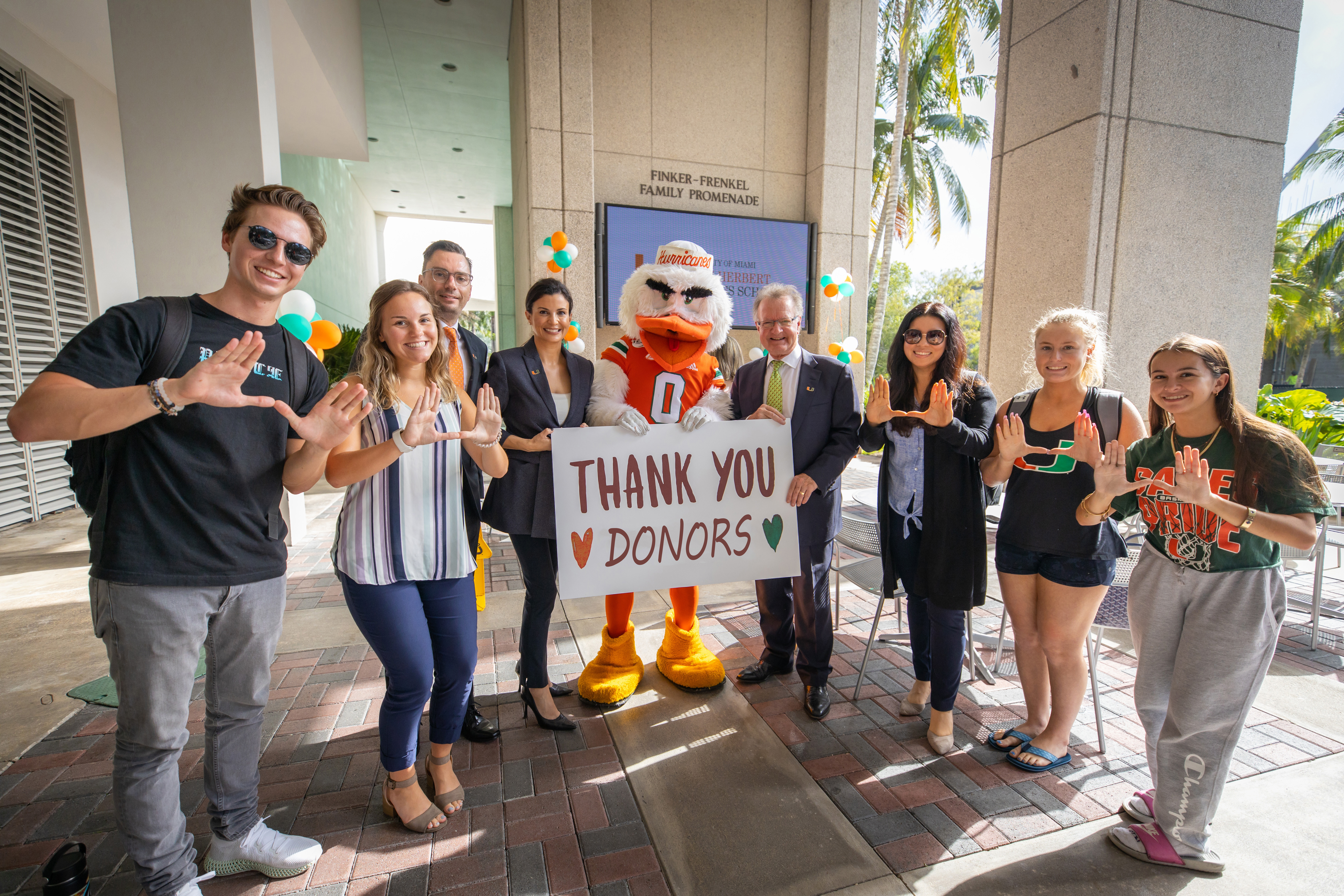 Students and Dean Quelch hold a “thank you donors” sign.