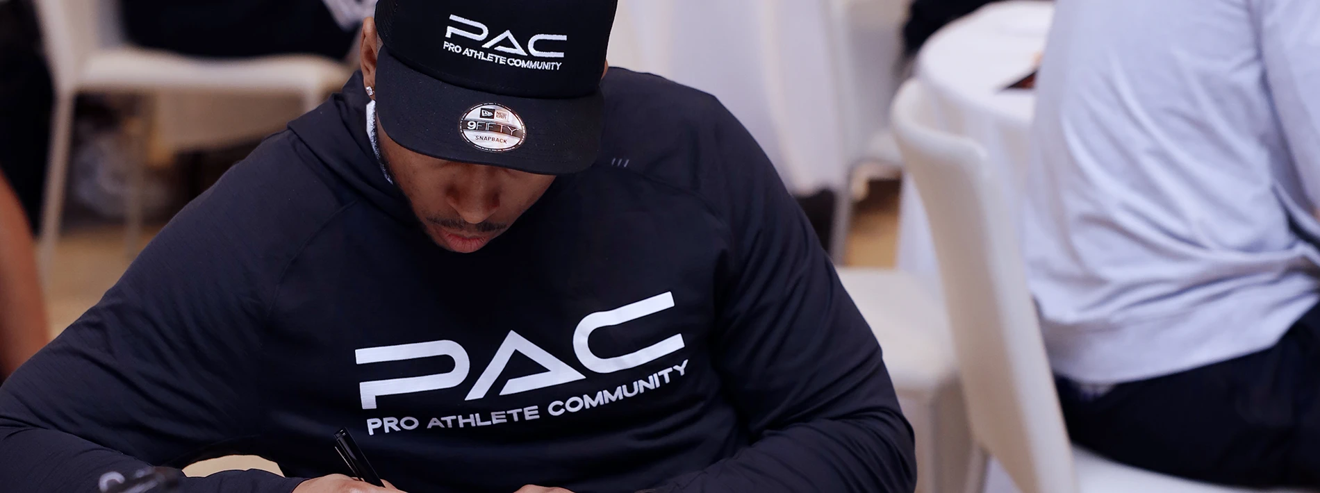 man with PAC hat and shirt fills out paperwork