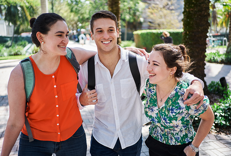 Three students walk together on campus