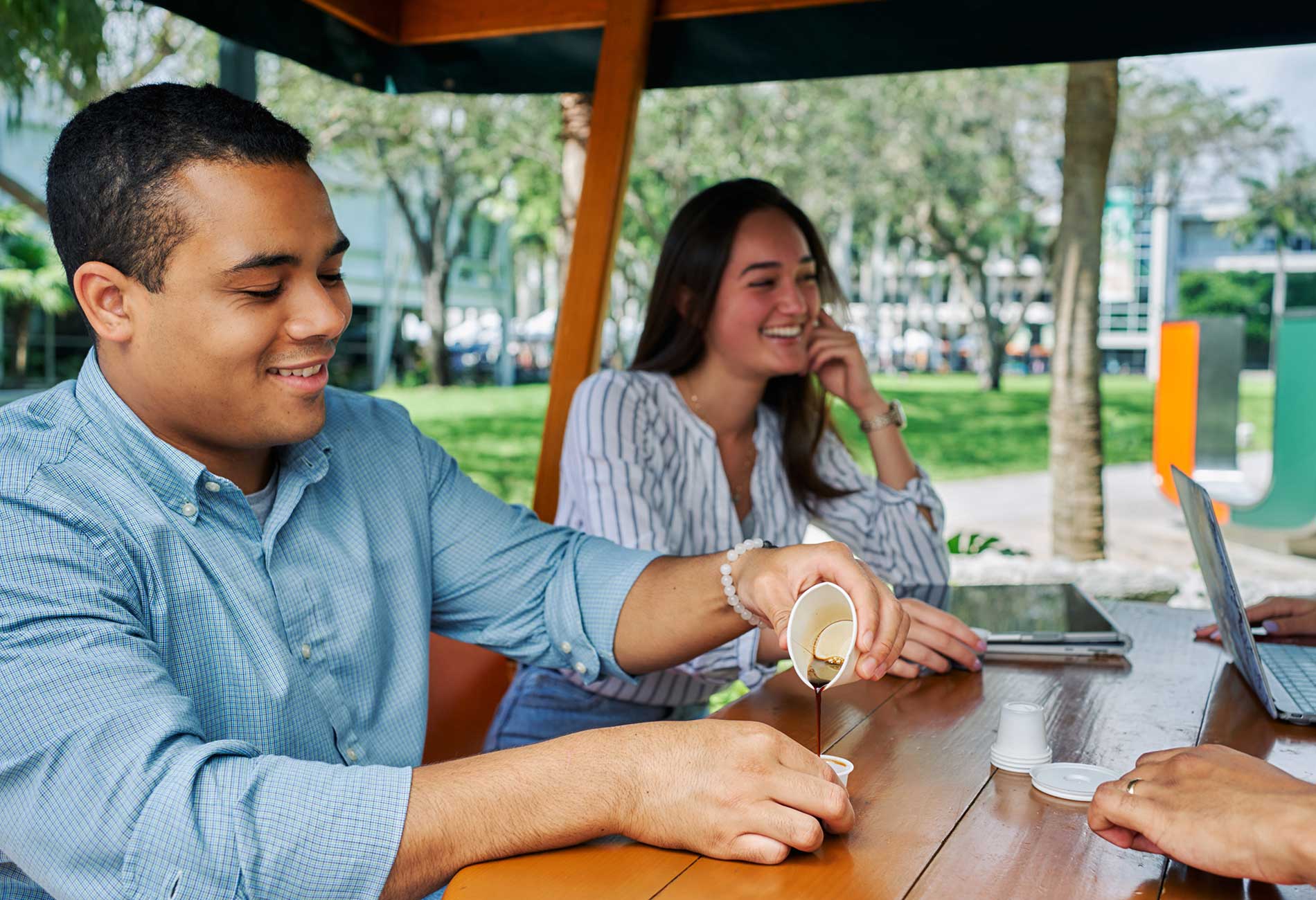 Two students sit at a table having coffee