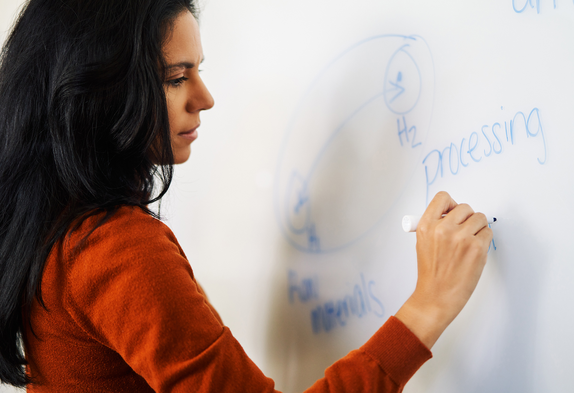 A female student writes on a smartboard
