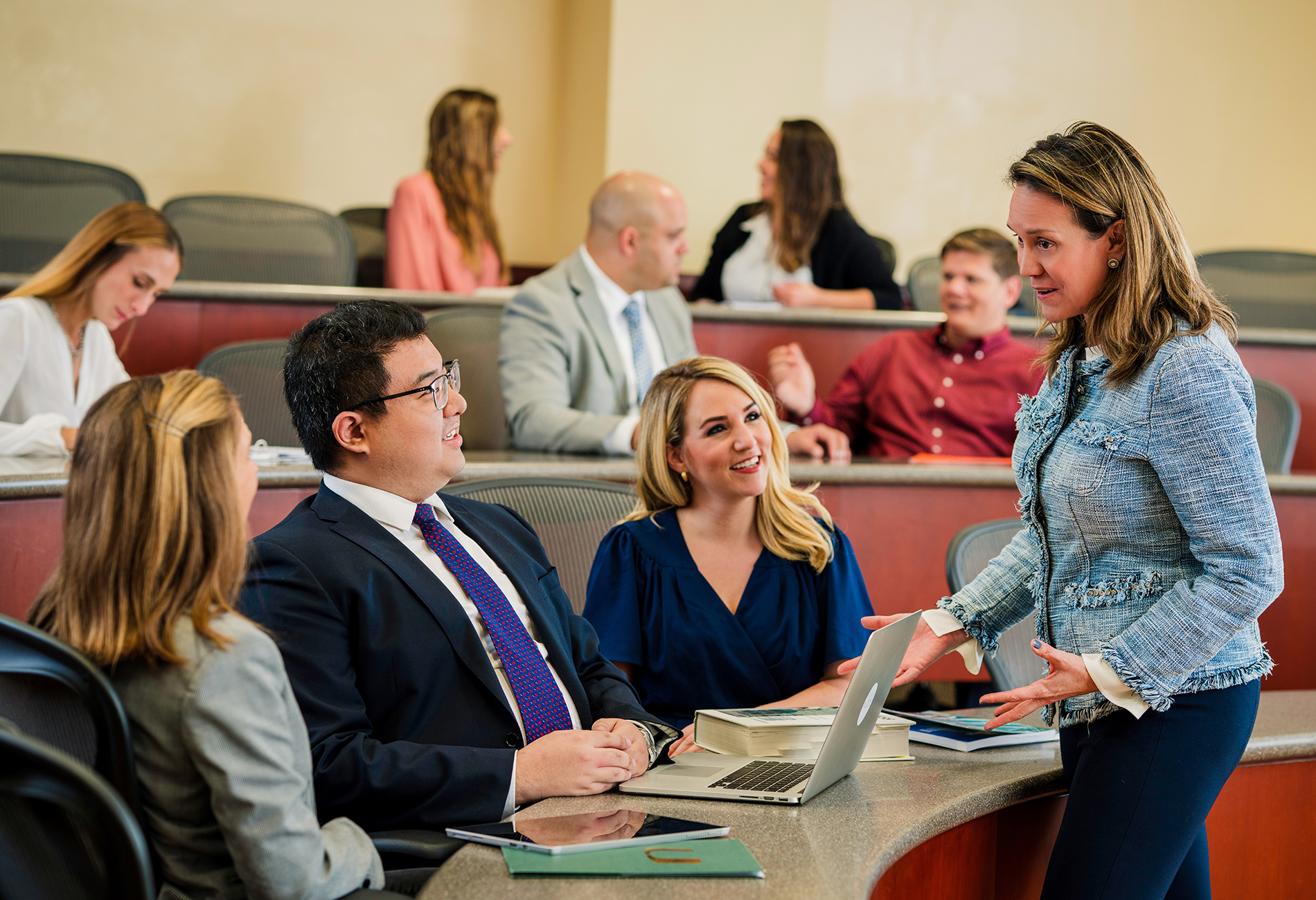 A female professor has a discussion with students in a classroom