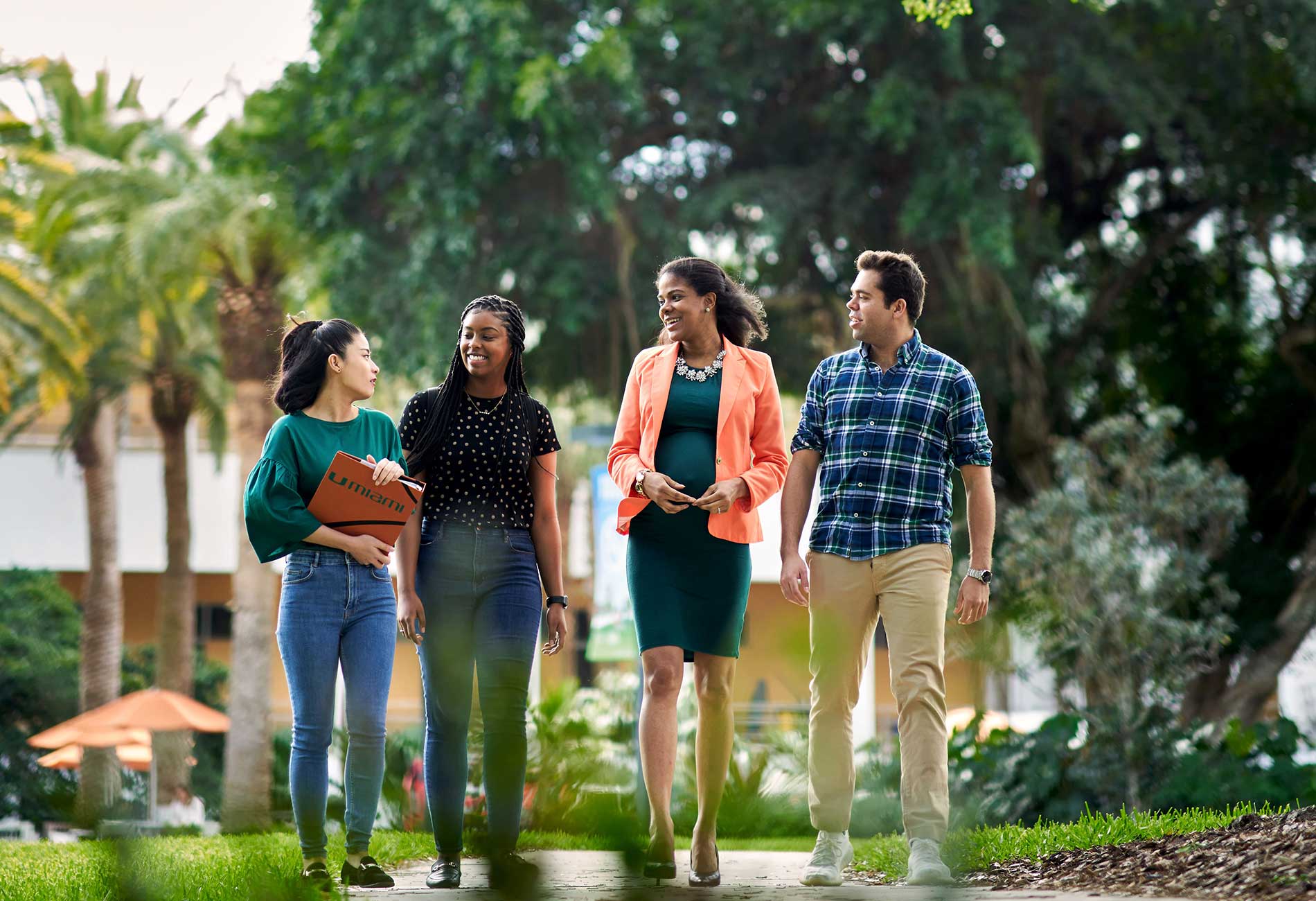 Students walking with professor. Students talking with professor outdoors.