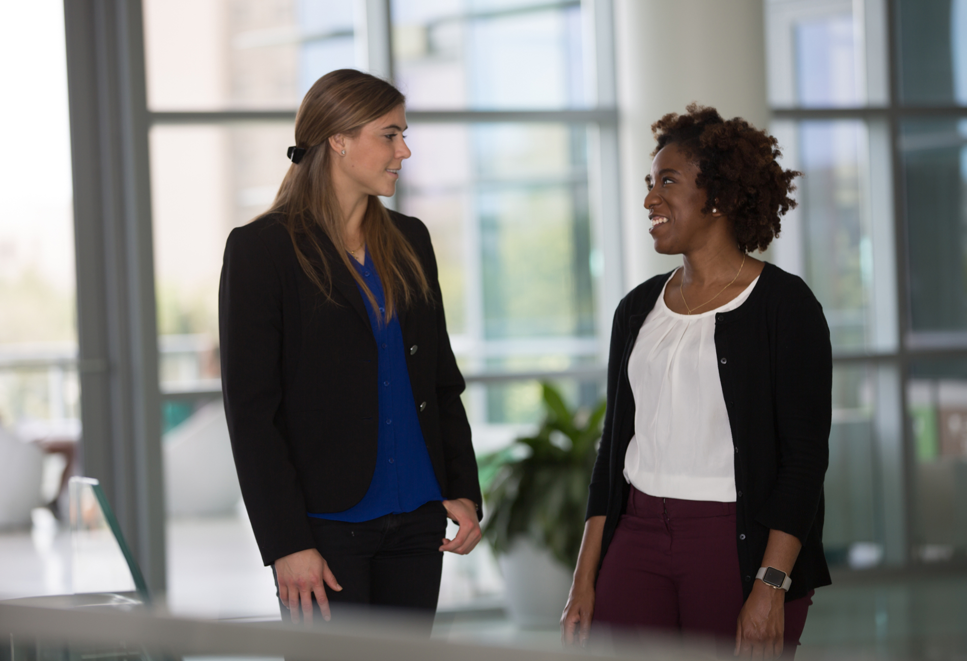 Two graduate students talking indoors.