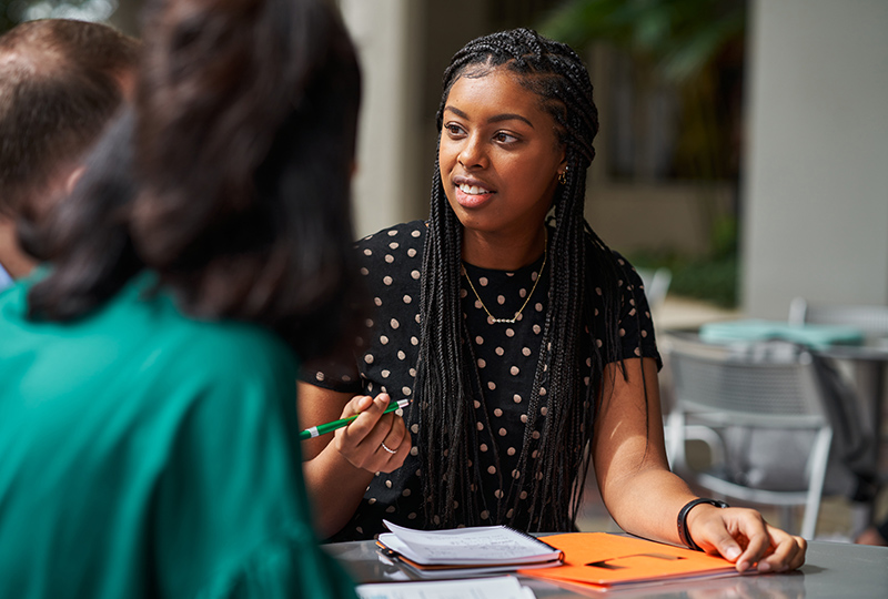 Female student discusses a program with classmates