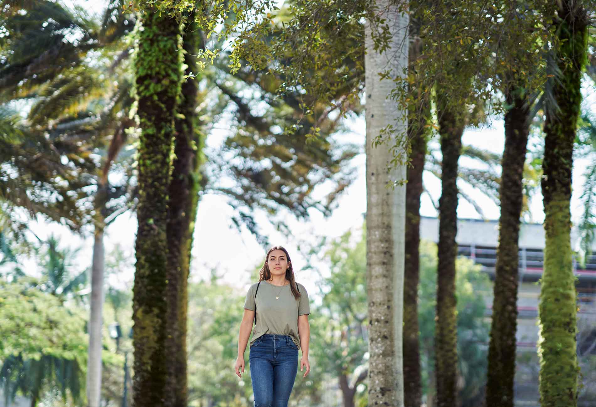 A female student walks on campus on a sunny day