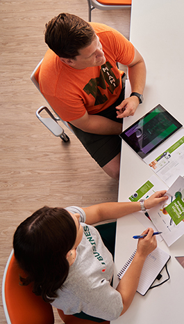 Two business students sit at a table having a discussion