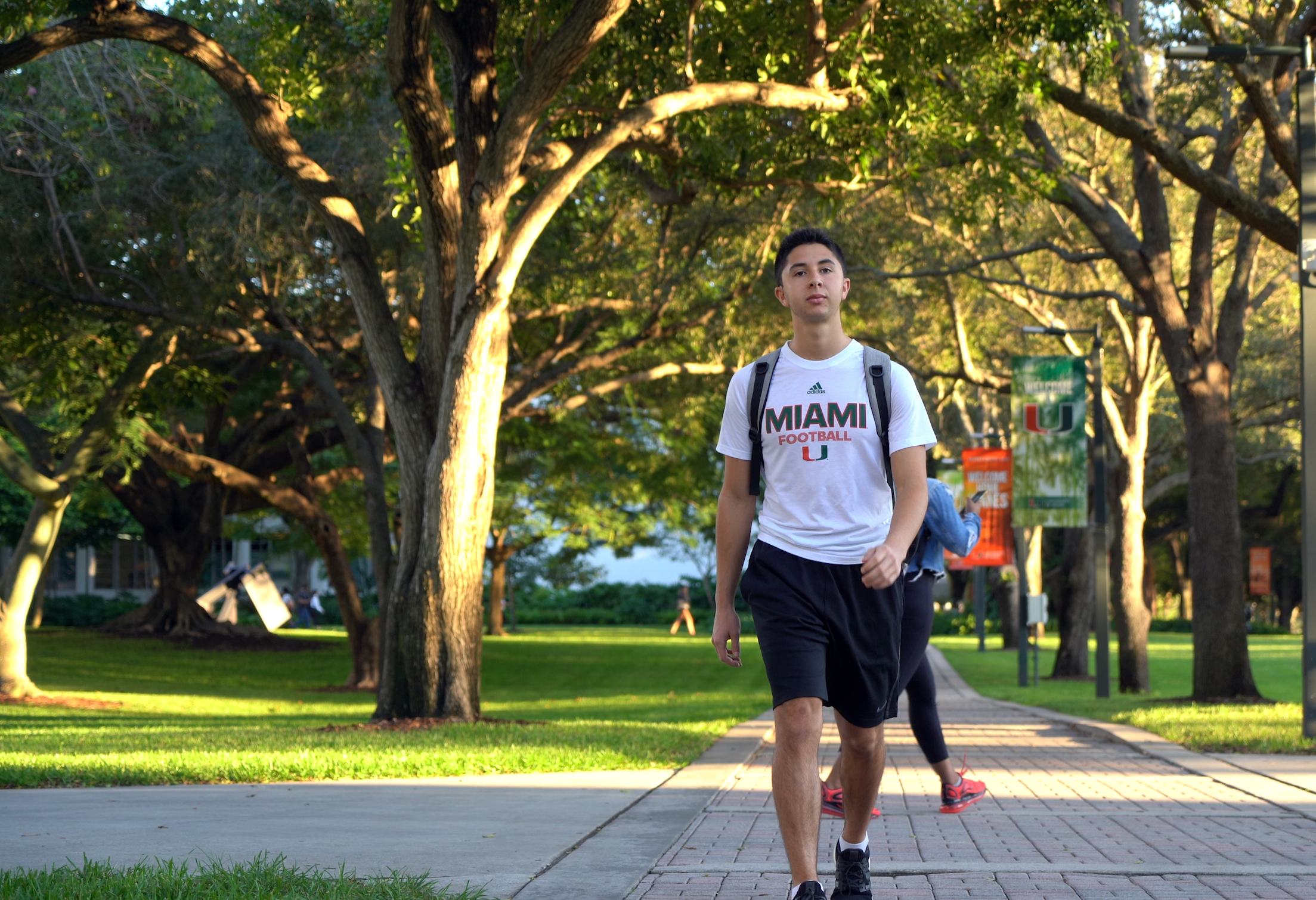 Male undergraduate business student walking through campus.