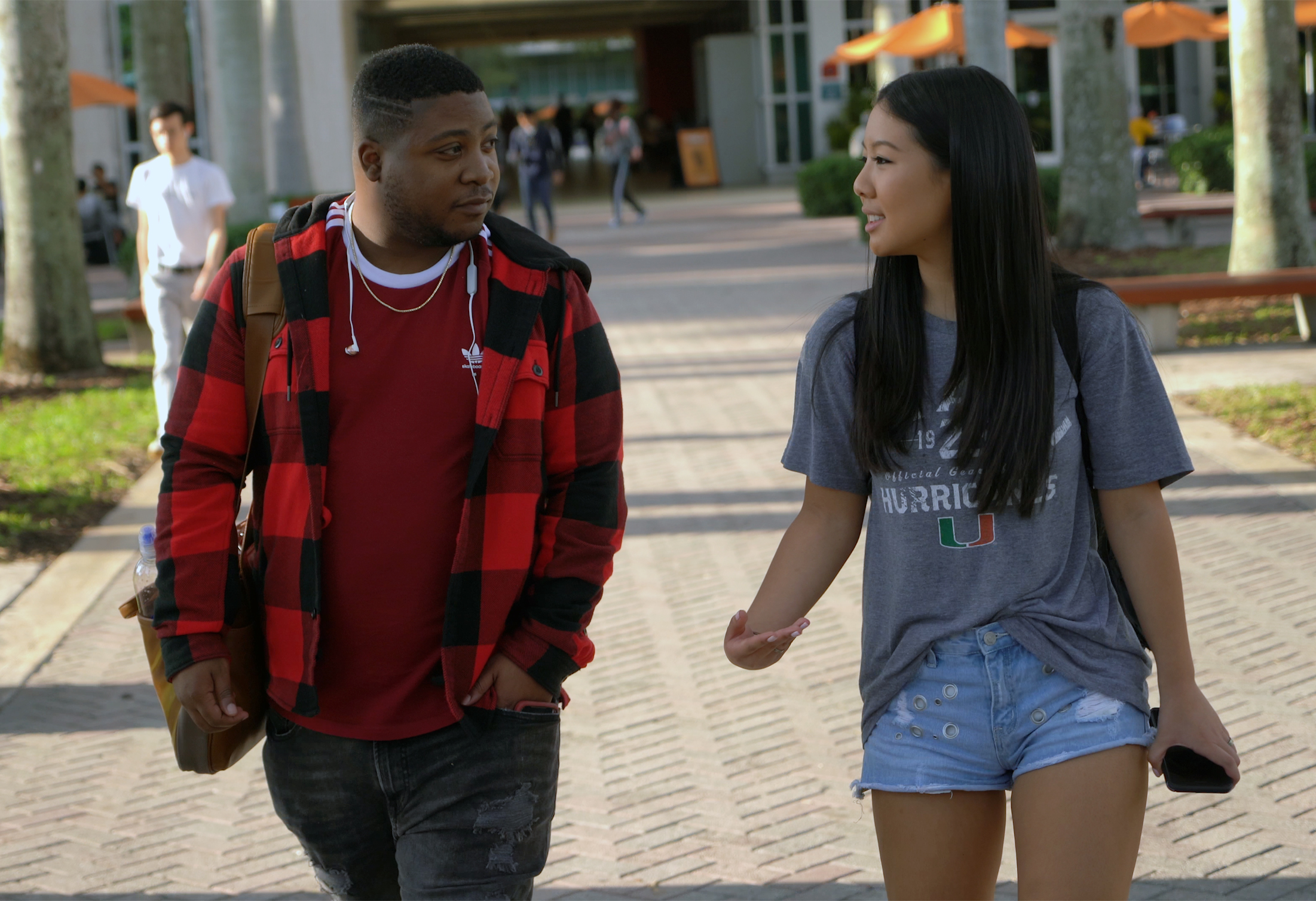 Two students talking while walking on campus.