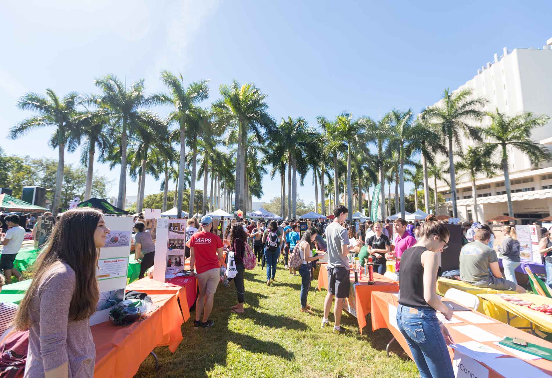 Gathering of all student clubs and organizations outdoors, blue sky in the background.