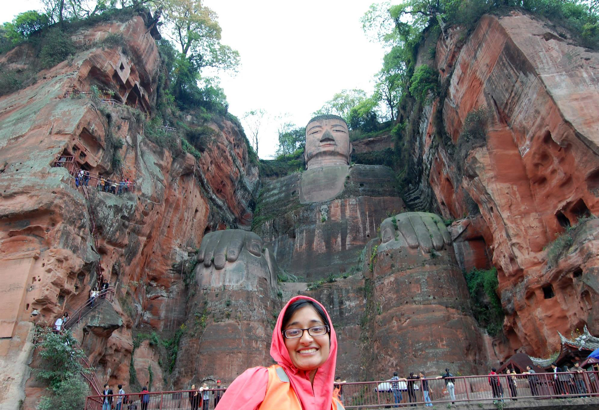 Female student studying abroad pictured in the Leshan Giant Buddha carved into the side of a mountain.